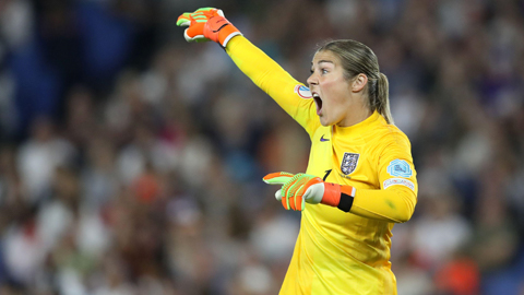 Mary Earps pointing, wearing a yellow football kit